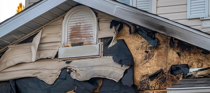 A close-up view of a neighborhood garage roof, which bears the scars of recent accidental fire damage