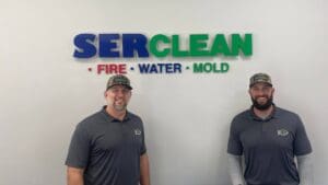 serclean employees standing in front of company logo on wall