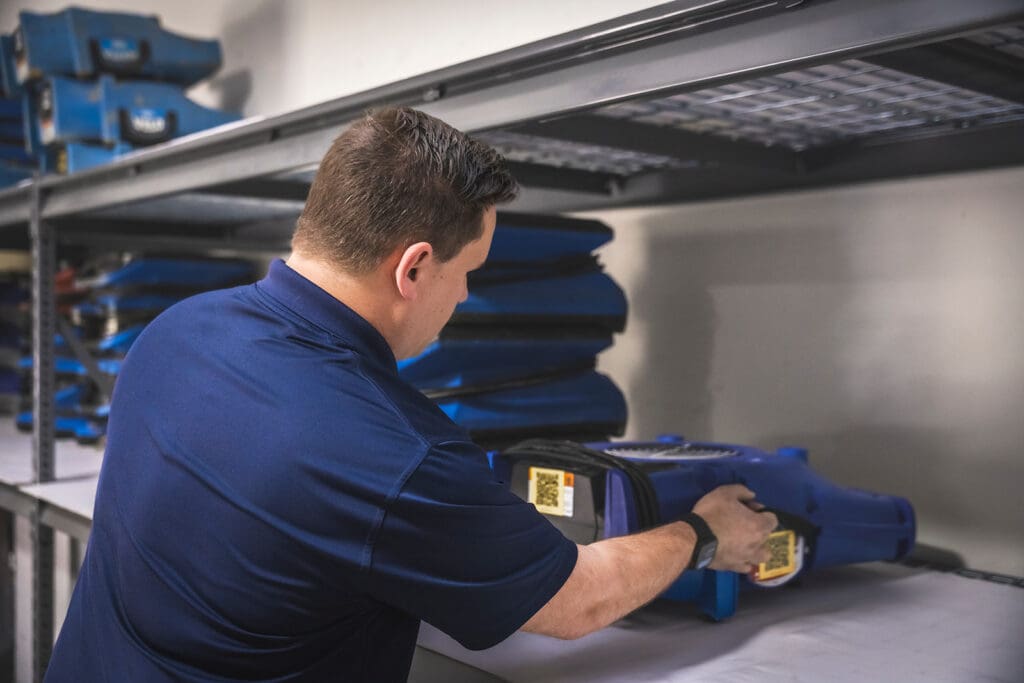 serclean technician grabbing dehumidifier and fan for water damage restoration in lawrenceville, georgia