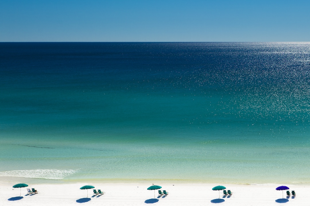 Beach umbrellas and deck chairs on beach, Destin, Florida, USA